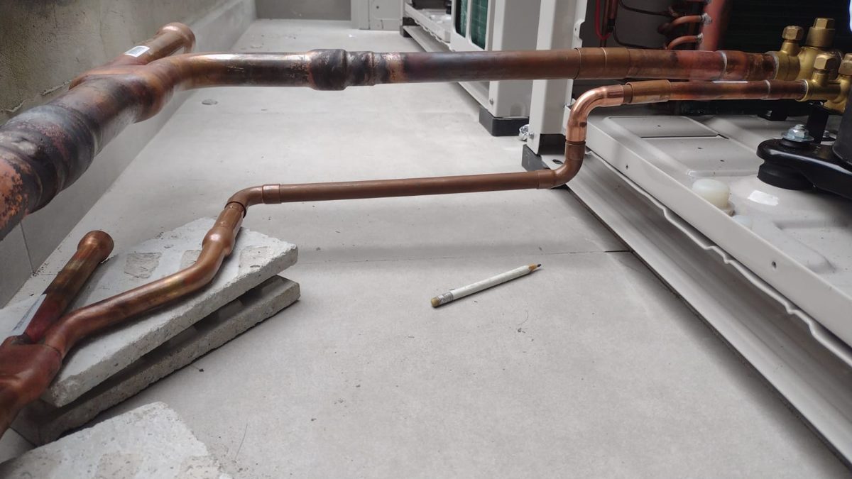 Detalhe de tubulação de cobre curvada com precisão em instalação VRF