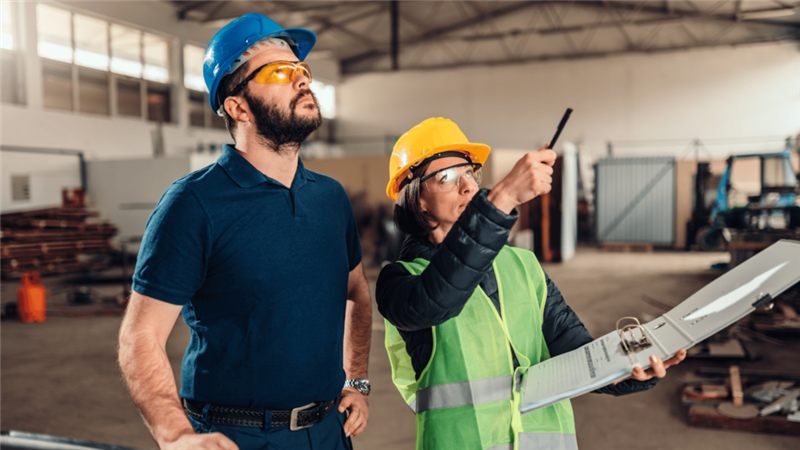 Equipe técnica com EPI vistoriando a obra de montagem de uma loja