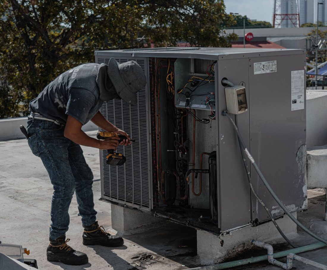 Técnico realizando manutenção em unidade de climatização comercial